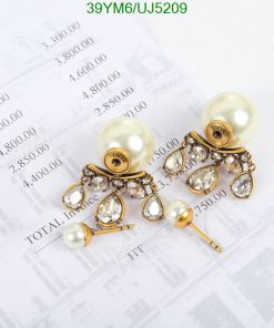 Pearl and crystal chandelier earrings on financial paper.