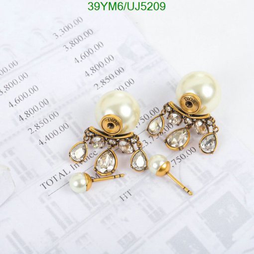 Pearl and crystal chandelier earrings on financial paper.