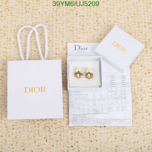 Dior earrings with packaging and receipt on textured background.