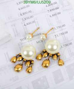 Pearl and gold floral dangle earrings on invoice background.