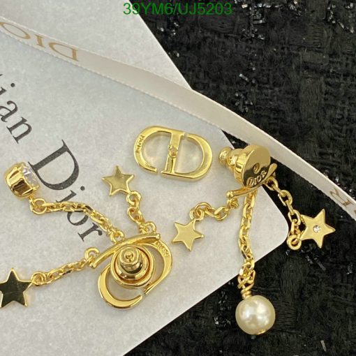 Gold designer earrings with star and pearl accents.