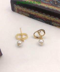 Gold pearl earrings on white surface.