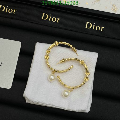 Gold pearl earrings on Dior branded display.