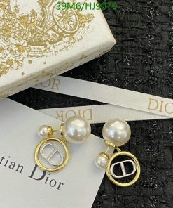 Pearl earrings with gold accents on branded background.