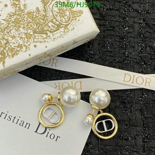 Pearl earrings with gold accents on branded background.