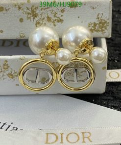 Gold and pearl designer logo earrings on display.