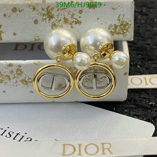 Gold and pearl designer logo earrings on display.