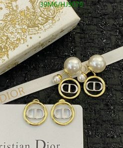 Pearl earrings with gold-tone accents on textured background.