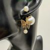 Butterfly earring on mannequin ear display.