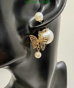 Butterfly earring on mannequin ear display.