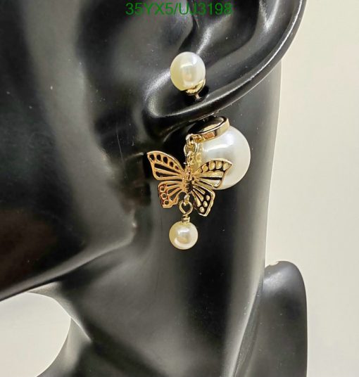 Butterfly earring on mannequin ear display.