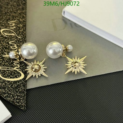 Gold sunburst earrings with pearls on desk.