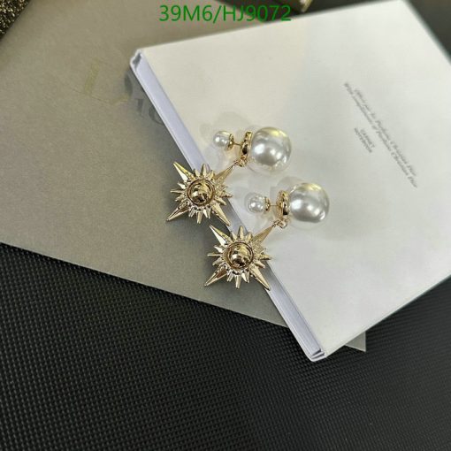 Gold starburst pearl earrings on book