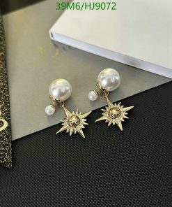 Pearl and sunburst design earrings on desk.