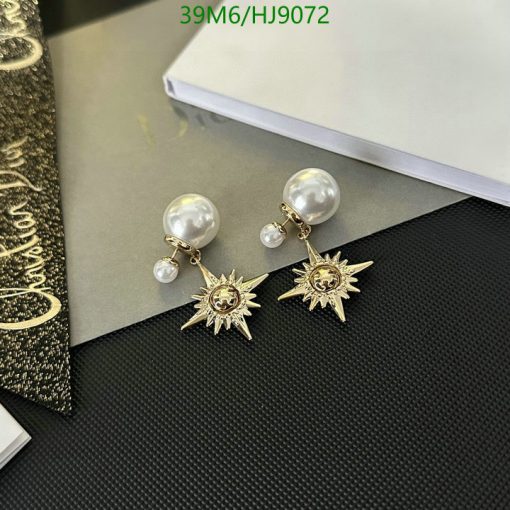 Pearl and sunburst design earrings on desk.