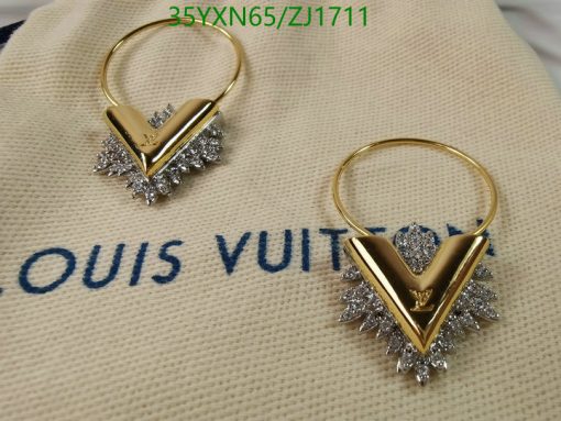 Designer gold-tone logo earrings on branded fabric.