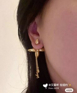 Woman's ear with unique gold dangle earring.