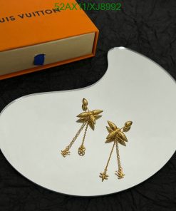 Gold flower earrings on white display with orange box.