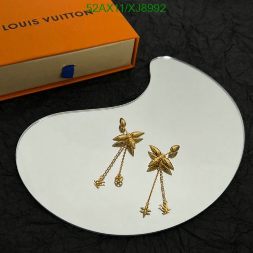 Gold flower earrings on white display with orange box.