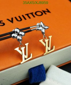 Designer earrings on Louis Vuitton book.