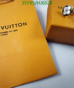 Louis Vuitton packaging with jewelry on table.