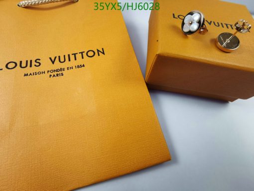 Louis Vuitton packaging with jewelry on table.