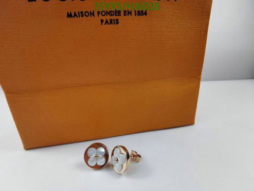 Elegant cufflinks with floral design before branded box.