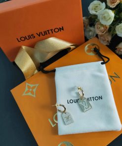 Louis Vuitton earrings on branded packaging with flowers.