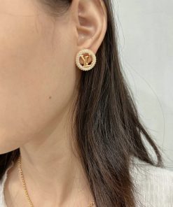 Woman wearing circular gold stud earring.