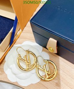 Designer gold hoop earrings on display with box