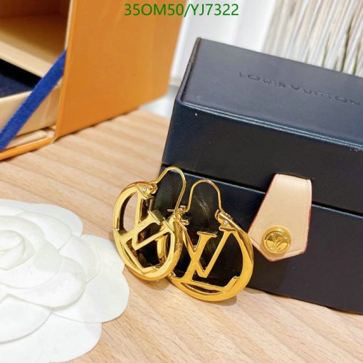 Gold-tone logo earrings on display with box.