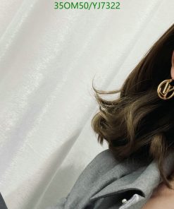 Woman with stylish earring and wavy hair.