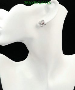 Flower-shaped earring on mannequin's ear.