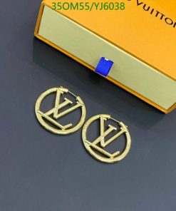 Designer brand logo earrings on table with box.