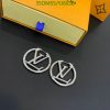 Designer logo earrings with packaging on table.