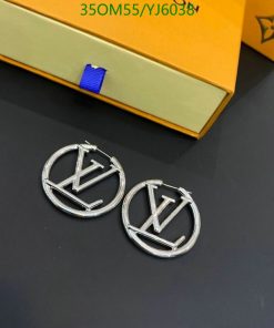 Designer logo earrings with packaging on table.