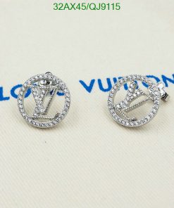 Designer logo stud earrings with crystals on fabric.