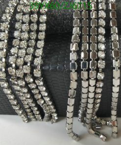 Assorted sparkling fashion bracelets on black textured background.