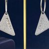 Diamond triangle earrings on gold stand.