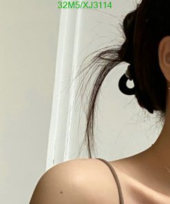 Woman with ponytail and hoop earring.