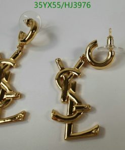 Gold-tone anchor-shaped dangling earrings on white background.