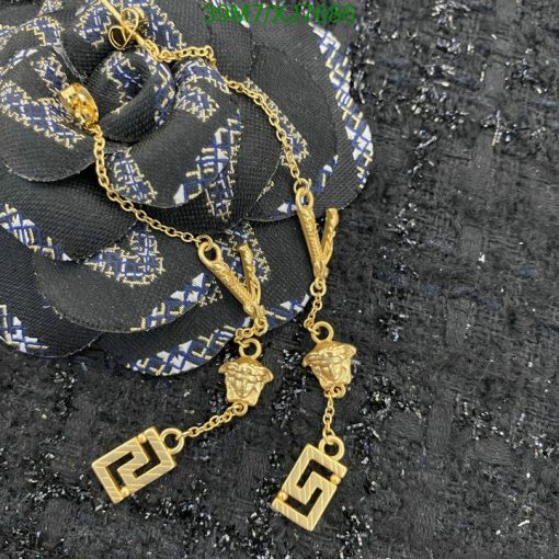 Gold pendant necklaces on black textured background.