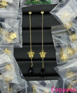 Gold chain earrings with black pendants, jewelry display