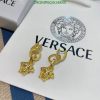 Gold designer earrings on branded box.