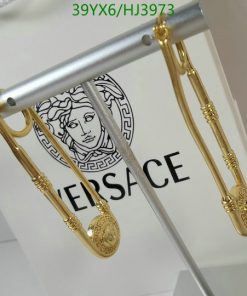 Gold-toned earrings with brand logo on display