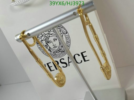 Gold-toned earrings with brand logo on display