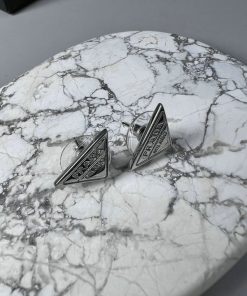 Silver cufflinks on marble surface.