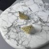 Designer cufflinks on marble surface.