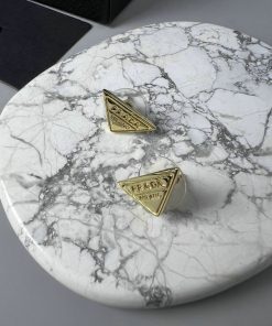 Designer cufflinks on marble surface.