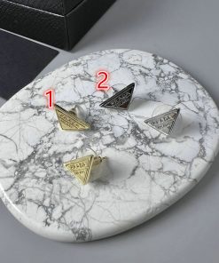 Designer cufflinks on marble background.